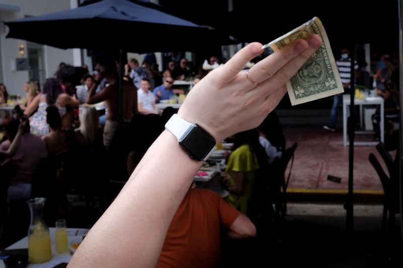&copy; Reuters. Homem segura nota de um dólar em bar em Miami Beach, Flórida, EUA
06/03/2021
REUTERS/Marco Bello