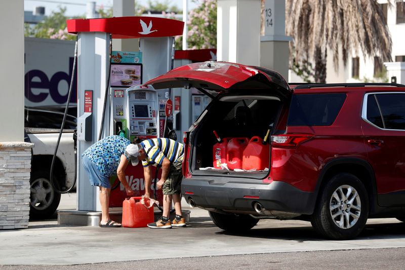 © Reuters. A couple fills up multiple 5 gallon gas tanks at a Wawa gas station, after a cyberattack crippled the biggest fuel pipeline in the country, run by Colonial Pipeline, in Tampa, Florida, U.S., May 12, 2021. REUTERS/Octavio Jones 