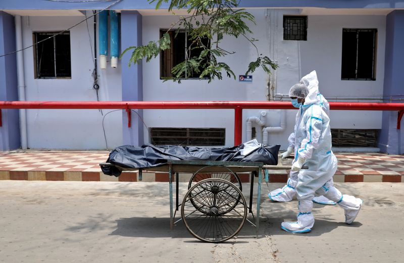 &copy; Reuters. Healthcare workers transfer the body of a person who died from the coronavirus disease (COVID-19), inside a hospital premises in Kolkata