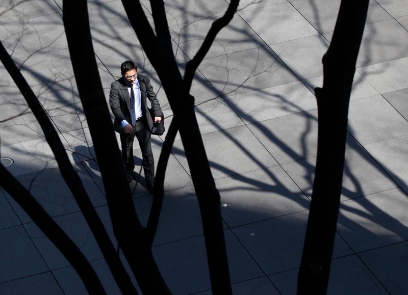 © Reuters. FILE PHOTO: A businessman walks through a business complex in Tokyo April 9, 2012.  REUTERS/Yuriko Nakao 