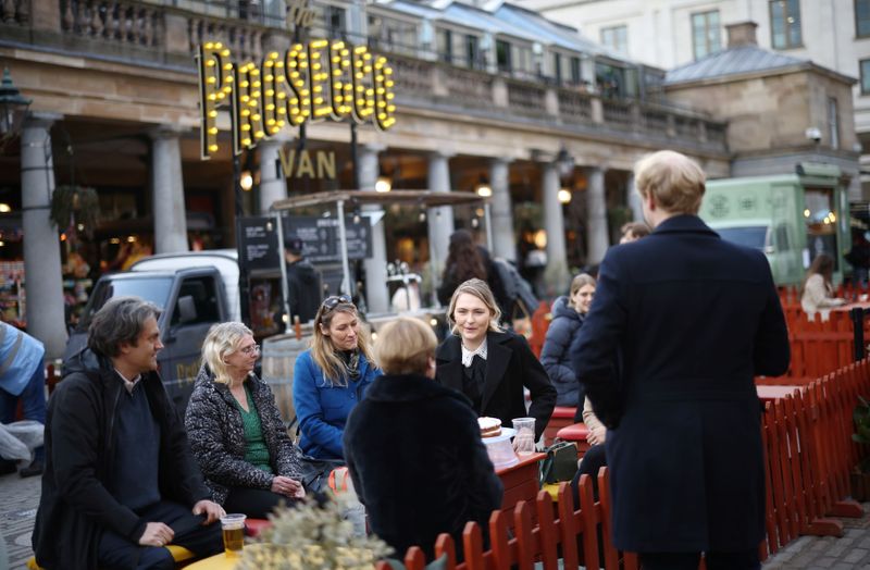 © Reuters. FILE PHOTO: People sit at outside a restaurant area, as the coronavirus disease (COVID-19) restrictions ease, at Covent Garden in London, Britain April 12, 2021. REUTERS/Henry Nicholls
