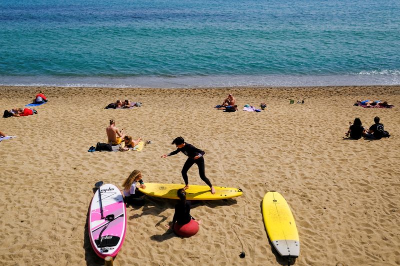 &copy; Reuters. FOTO DE ARCHIVO: Una persona enseña a hacer surf a los niños en la playa de la Barceloneta, en Barcelona, España, 3 de abril de 2021. REUTERS/Nacho Doce