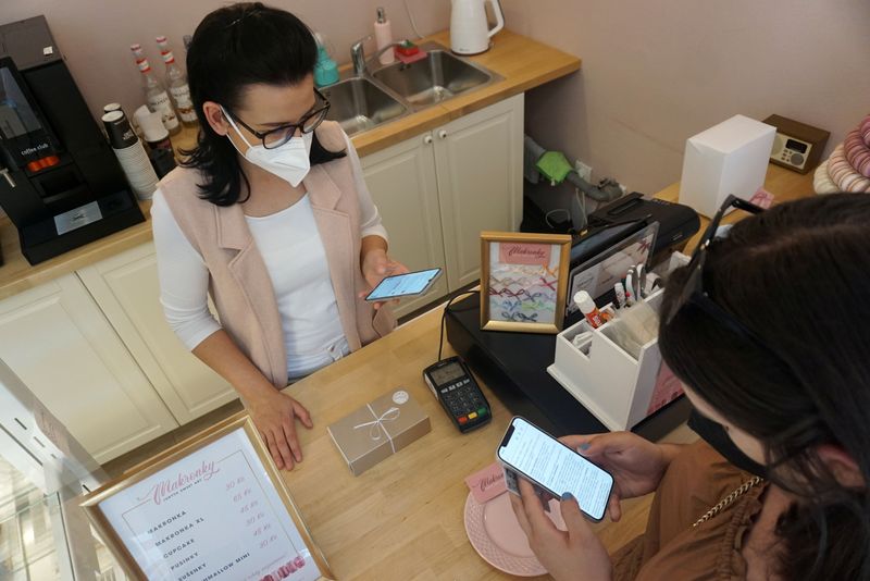 &copy; Reuters. Candy store owner Jitka Hornakova receives Corrency (covid currency) payment through a mobile application, amid the coronavirus disease (COVID-19) pandemic, in Kyjov, Czech Republic, May 12, 2021. REUTERS/Jiri Skacel