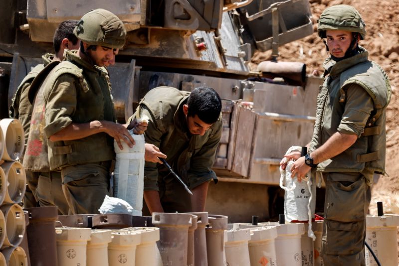 &copy; Reuters. Israeli soldiers check artillery shells in an area near the border with Gaza