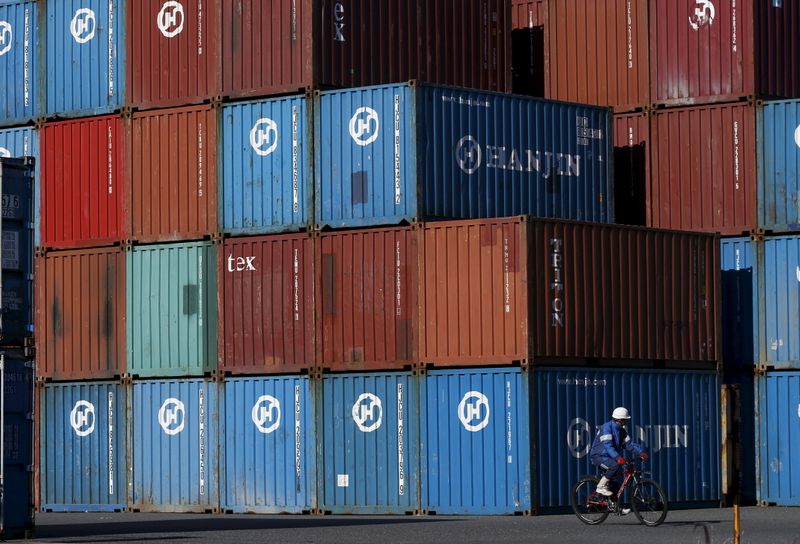 &copy; Reuters. FILE PHOTO: A worker rides a bicycle in a container area at a port in Tokyo, Japan January 25, 2016. REUTERS/Toru Hanai