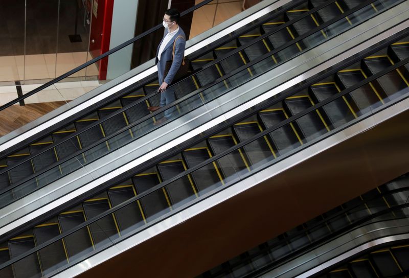 © Reuters. FILE PHOTO: A man wearing a mask takes the escalator, amid the coronavirus disease (COVID-19) outbreak in Singapore