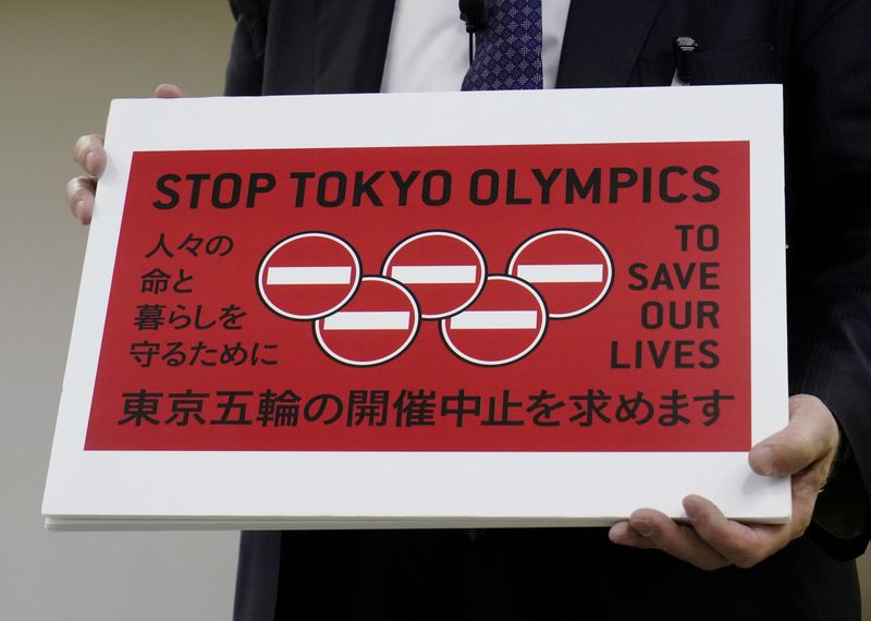 &copy; Reuters. Lawyer Kenji Utsunomiya shows off a placard during a news conference after he and anti-Olympics petition organizer to submit a petition calling for the Tokyo 2020 Olympics to be cancelled to Tokyo Governor Yuriko Koike (not in picture) at the Tokyo Metrop