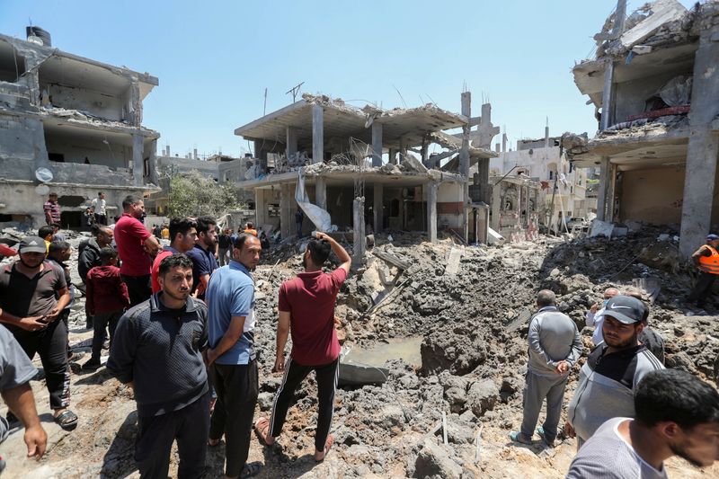 &copy; Reuters. Palestinos se reúnem perto de casas destruídas por ataques aéreos e de artilharia de Israel no norte da Faixa de Gaza
14/05/2021 REUTERS/Mohammed Salem