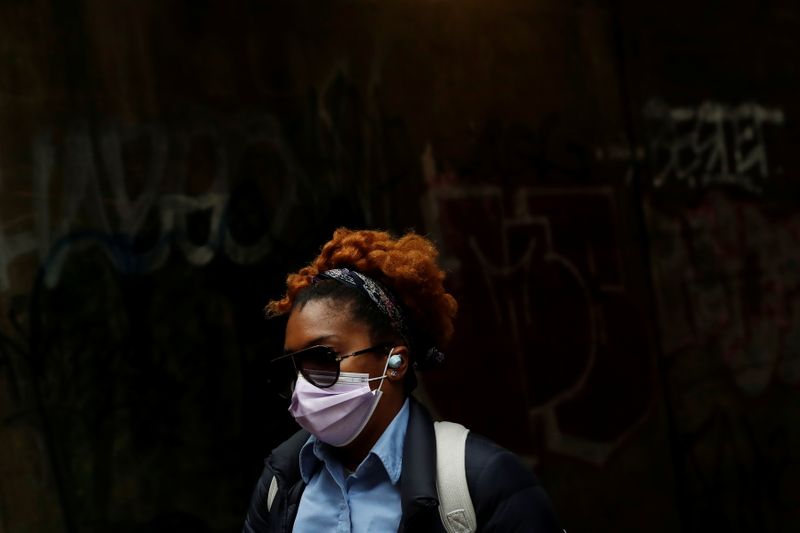 &copy; Reuters. FILE PHOTO: A woman wearing a protective mask walks under the subway in the Brownsville section of the Brooklyn borough of New York City, U.S., May 3, 2021. REUTERS/Shannon Stapleton