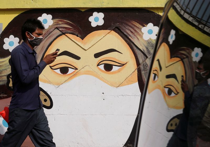 &copy; Reuters. Un hombre pasa junto a un graffiti de una niña con mascarilla, calle de Navi Mumbai, India, 21 enero 2021.
REUTERS/Francis Mascarenhas