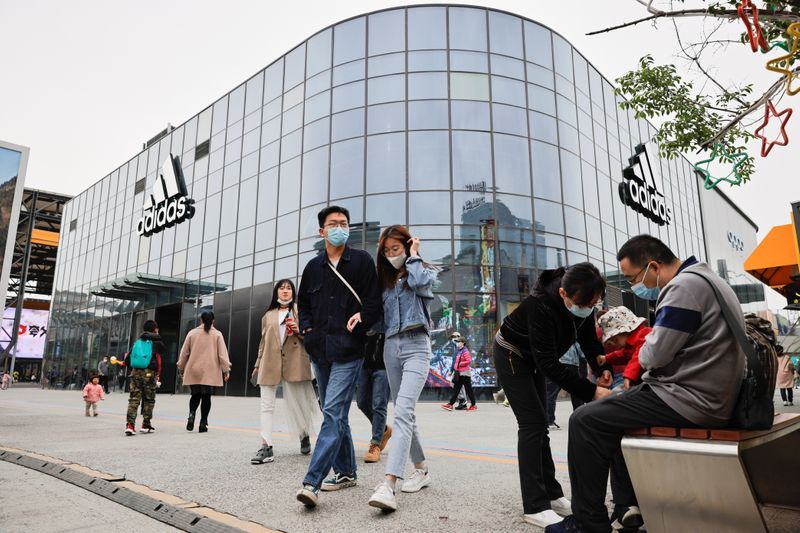 &copy; Reuters. La gente pasa frente a una tienda Adidas en un distrito comercial, Pekín, China, 5 abril 2021.
REUTERS/Thomas Peter