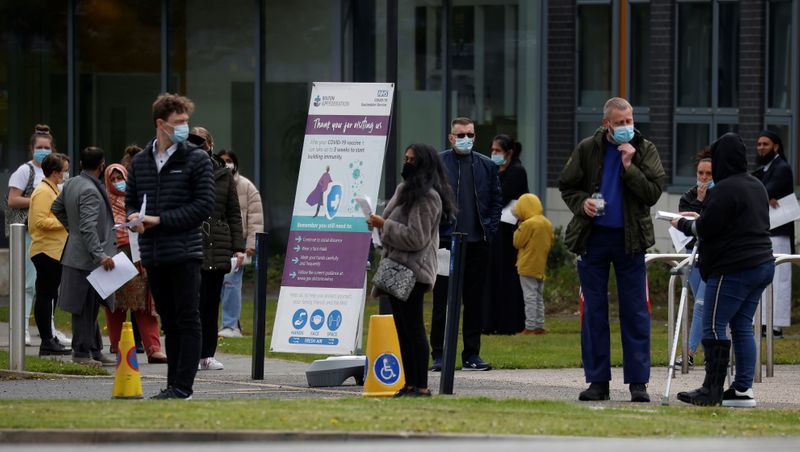 © Reuters. FILE PHOTO: People line up outside a mobile vaccination centre, amid the outbreak of the coronavirus disease (COVID-19), in Bolton, Britain, May 13, 2021. REUTERS/Phil Noble