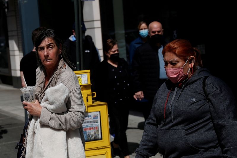 &copy; Reuters. FILE PHOTO: A woman walks without a protective face mask, after the Centers for Disease Control and Prevention (CDC) announced new guidelines regarding outdoor mask wearing and vaccinations during the outbreak of the coronavirus disease (COVID-19) in Manh