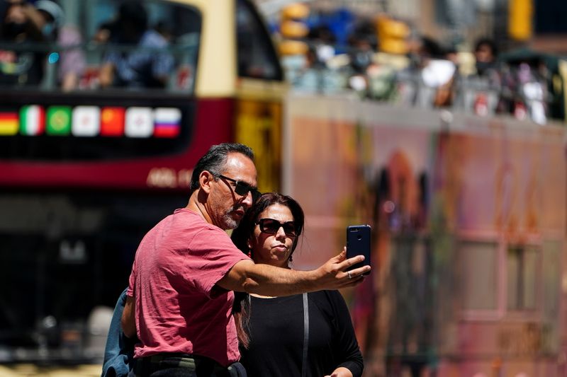 &copy; Reuters. Personas sin máscarillas posan para fotos en Times Square durante la pandemia del coronavirus (COVID-19) en el barrio de Manhattan de la ciudad de Nueva York,  Estados Unidos. 14 de mayo de 2021.  REUTERS/Carlo Allegri