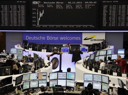 © Reuters. File photo of traders working at their desks in front of the DAX board and banner reading 'Deutsche Boerse Welcomes Ultrasonic' at the Frankfurt stock exchange