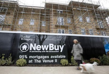 © Reuters. A woman walks past a new residential property development in London