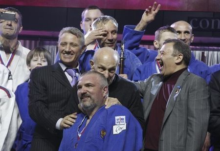 © Reuters. Businessmen Rotenberg and Rotenberg react during an awarding ceremony of a judo competition in St. Petersburg