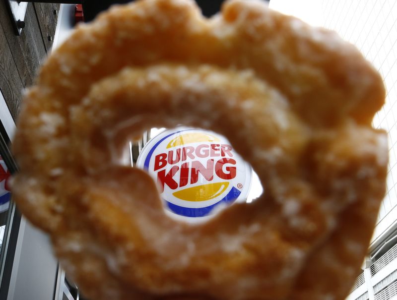 &copy; Reuters The Burger King logo is seen through a Tim Horton's doughnut hole in a photo illustration outside a restaurant in Toronto