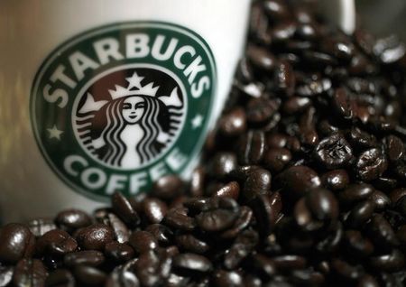 © Reuters. A mug bearing a Starbucks logo is pictured next to coffee beans during a news conference in Tokyo