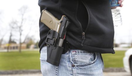 © Reuters. A gun rights supporter carries his Ruger model SR9 pistol on his hip during a rally in support of the Michigan Open Carry gun law in Romulus