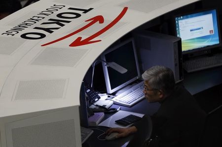 © Reuters. An employee of the Tokyo Stock Exchange (TSE) looks at a monitor at the bourse at the TSE in Tokyo