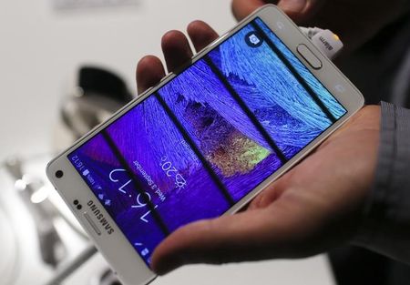 © Reuters. A visitor holds a new Samsung Galaxy Note 4 smartphone after its presentation at the Unpacked 2014 Episode 2 event ahead of the IFA Electronics show in Berlin