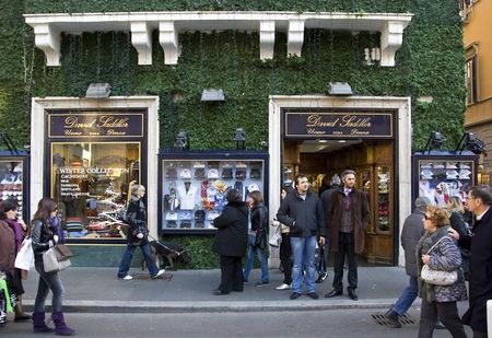 © Reuters. People walk in front of shop in downtown Rome