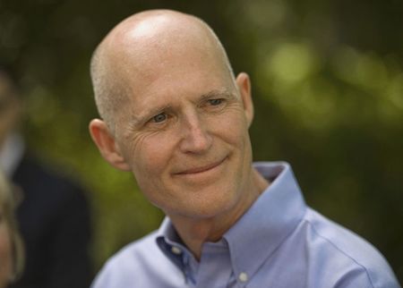 © Reuters. Scott talks with reporters after visiting a campaign office in Tampa