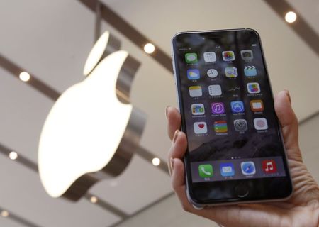 © Reuters. A woman holds up the iPhone 6 Plus at the Apple Store in Tokyo