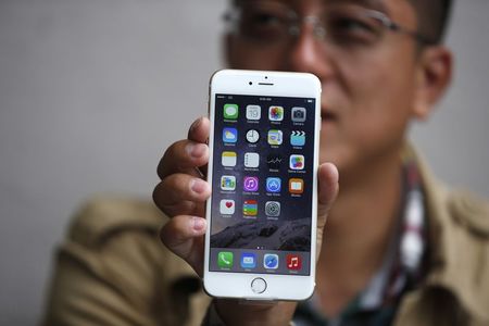 © Reuters. Tony Zhan, 32, holds up his new iPhone 6 Plus after it went on sale at the Apple store in Pasadena