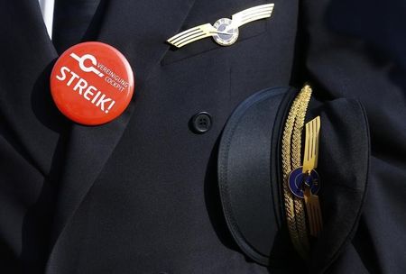 © Reuters. Lufthansa pilot wears badge reading "strike" on his uniform as he takes part in a demonstration at Fraport airport in Frankfurt