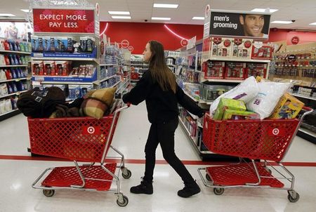 © Reuters. A woman pulls shopping carts through the aisle of a Target store on the shopping day dubbed 