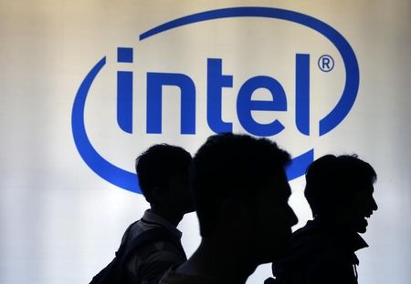 © Reuters. Indonesian youth walk past an Intel sign during Digital Imaging expo in Jakarta