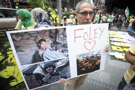 © Reuters. Homem segura cartaz com foto do jornalista James Foley  