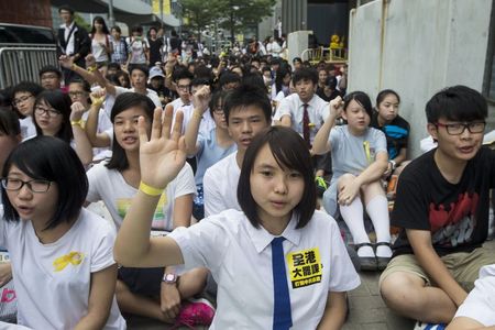 © Reuters. A secondary school student holds up a hand with a yellow ribbon tied around her wrist during a rally against Beijing's election framework for Hong Kong, outside government headquarters in Hong Kong