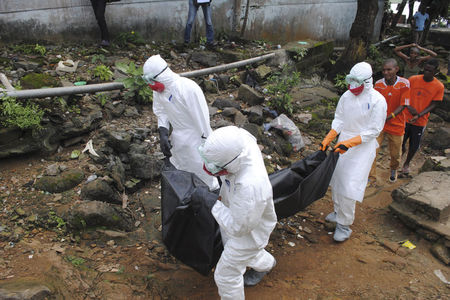 © Reuters. Health workers remove the body of Prince Nyentee, a man whom local residents said died of Ebola virus in Monrovia