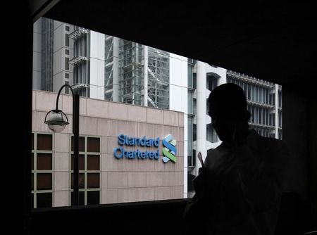 © Reuters. A man walks on a footbridge connected to the Standard Chartered headquarters in Hong Kong
