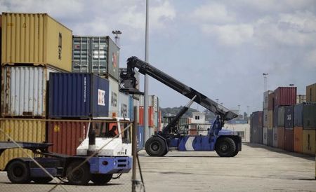 © Reuters. Men operate cranes at Havana Port's container terminal