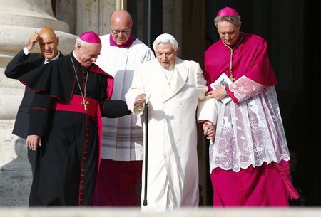 © Reuters. Emeritus Pope Benedict XVI is helped by Archbishops Georg Ganswein and Vincenzo Paglia as he arrives before a mass in Saint Peter's square at the Vatican