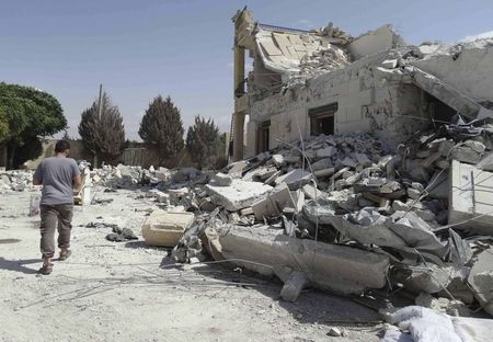 © Reuters. A man walks past damage at a base of the al Qaeda-linked Nusra Front, that was targeted by what activists said were U.S.-led air strikes in Reef al-Mohandeseen al-Thani in Aleppo