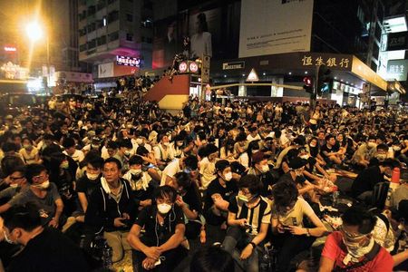 © Reuters. Cientos de manifestantes bloquean una calle principal en el barrio comercial Mogkok de Hong Kong