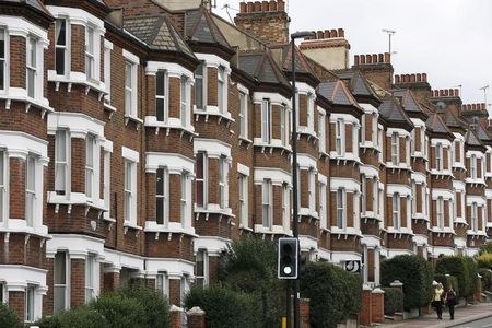 © Reuters. Pedestrian walk past houses in London