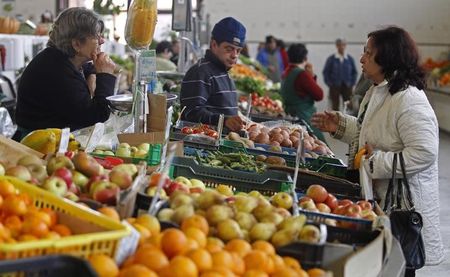 © Reuters. People talk at the vegetable market in Olhao