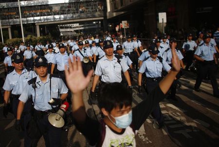© Reuters. Manifestante ergue os braços enquanto polícia tenta dispersar protesto perto de sede do governo de Hong Kong