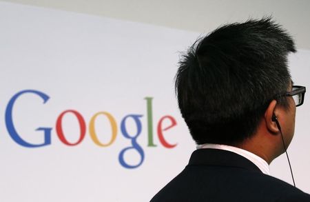 © Reuters. A man stands in front of a Google logo in Hong Kong