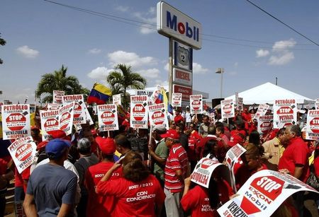 © Reuters. Supporters of Venezuel President Hugo Chavez protest in front of Mobil service station in Maracaibo