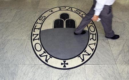 © Reuters. Man walks on a logo of the Monte Dei Paschi Di Siena bank in Rome