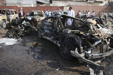 © Reuters. People inspect the site of a car bomb attack in Basra, southeast of Baghdad