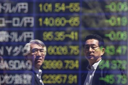 © Reuters. Tokyo businessmen are reflected in an electronic board showing exchange rates between the Japanese yen against foreign currencies and markets indices, outside a brokerage in Tokyo