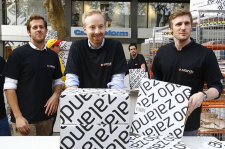 © Reuters. Zalando management board members Gentz Ritter and Schneider handle merchandising packages during the initial public offering of the company at the Frankfurt stock exchange